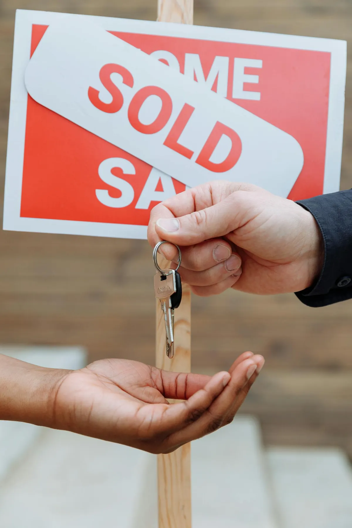 house keys with sold sign and contract